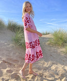A model stood in sand dunes wearing a Rose and Rose red striped linen Agrigento dress. 