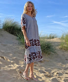 A model stood in the sand dunes wearing a Rose and Rose striped linen Agrigento dress.
