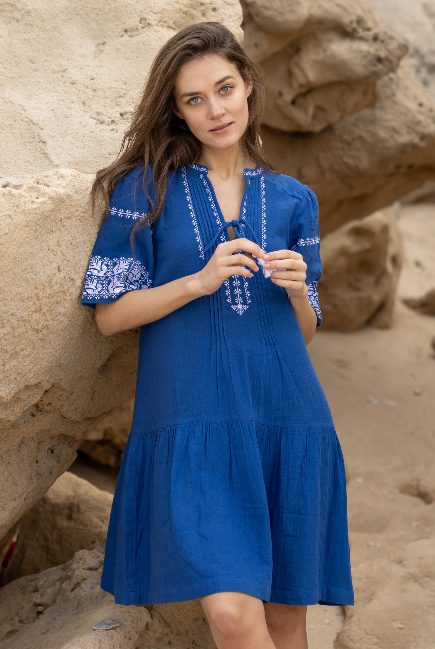 A model wears a Rose and Rose embroidered Ajaccio dress in french blue cotton.
