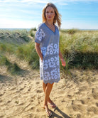 A model stood in sand dunes wearing a Rose and Rose striped cotton Amalfi dress. 