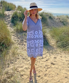 A model stood in sand dunes wearing a Rose and Rose striped cotton Amalfi dress and an Anthony Peto hat. 