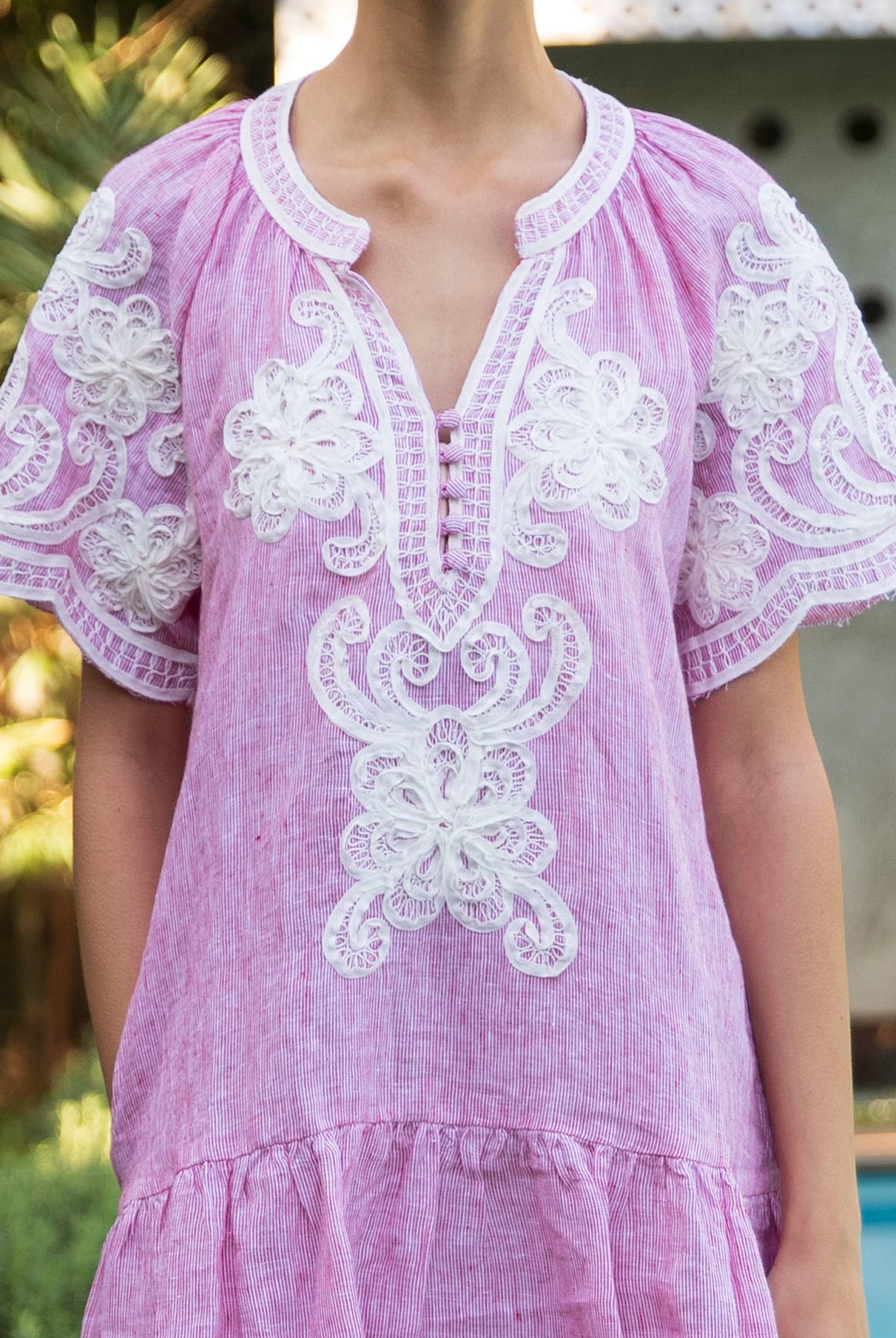 Details from the red striped Amaranta dress with white tape work decorations.