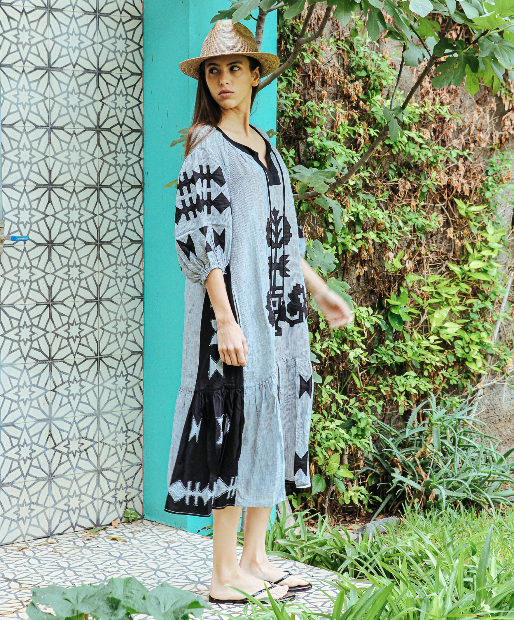 A side view of a model wearing a Rose and Rose Amersham striped linen dress.
