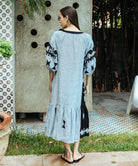 A back view of a model wearing a Rose and Rose Amersham striped linen dress.