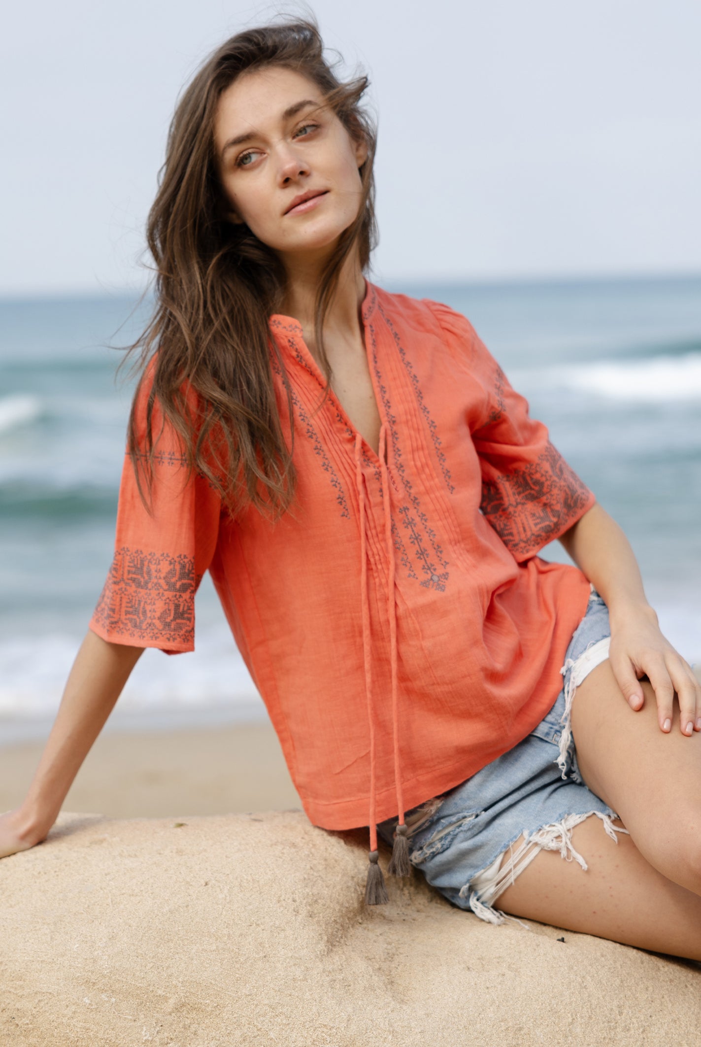 A model wears a Rose and Rose embroidered Antibes top in coral cotton.
