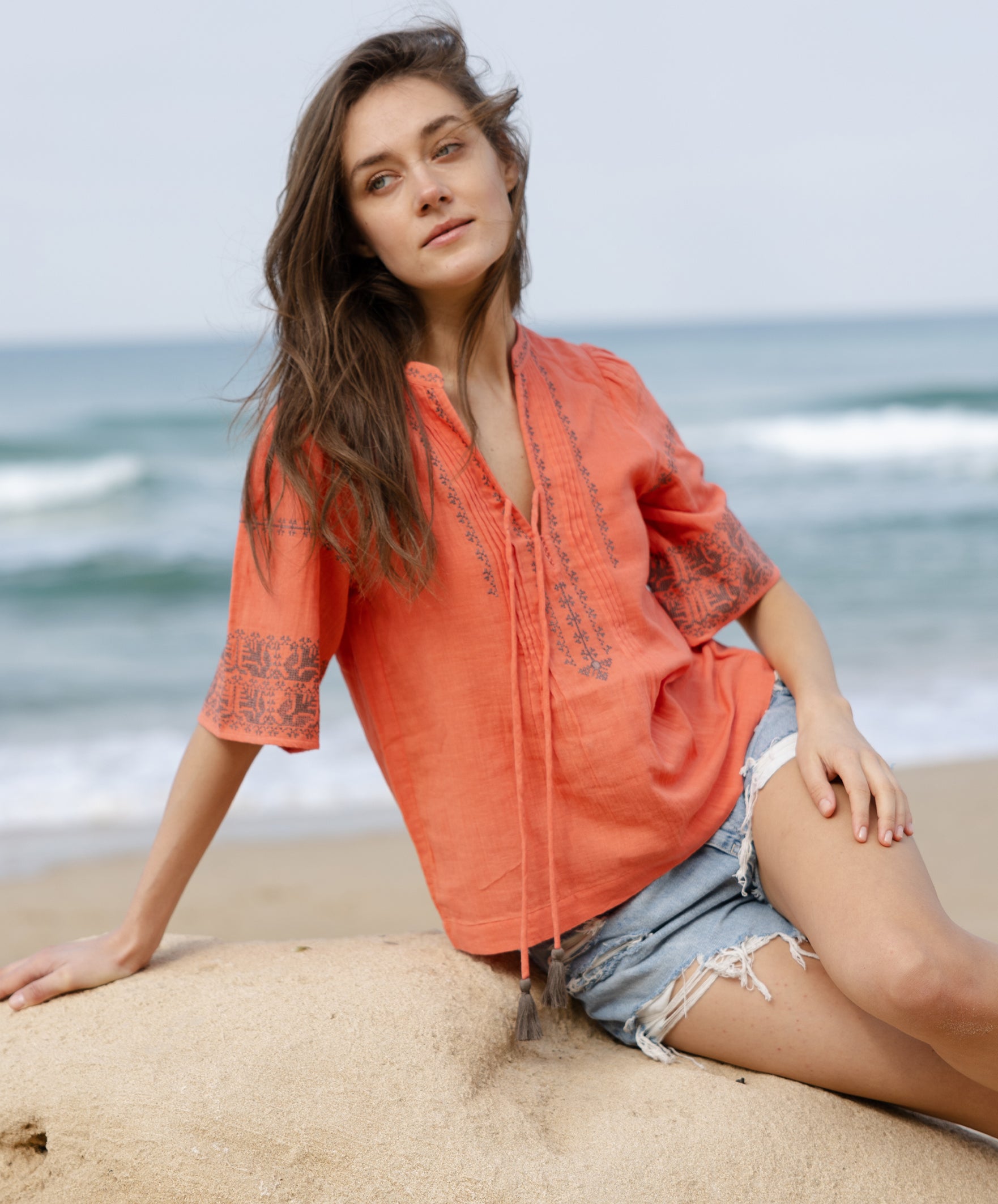 A model wears a Rose and Rose embroidered Antibes top in coral cotton.