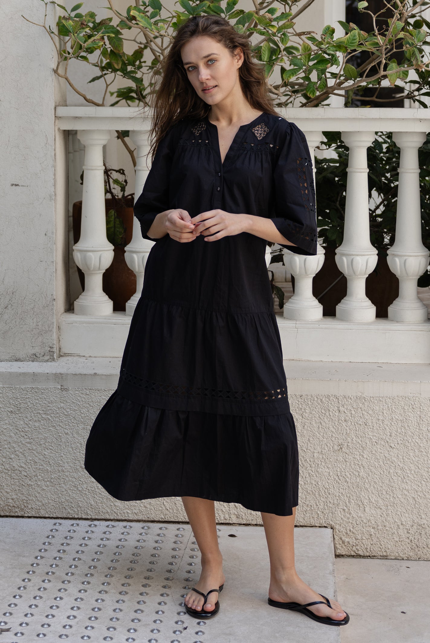 A model wears a Rose and Rose embroidered Biarritz dress in black cotton.