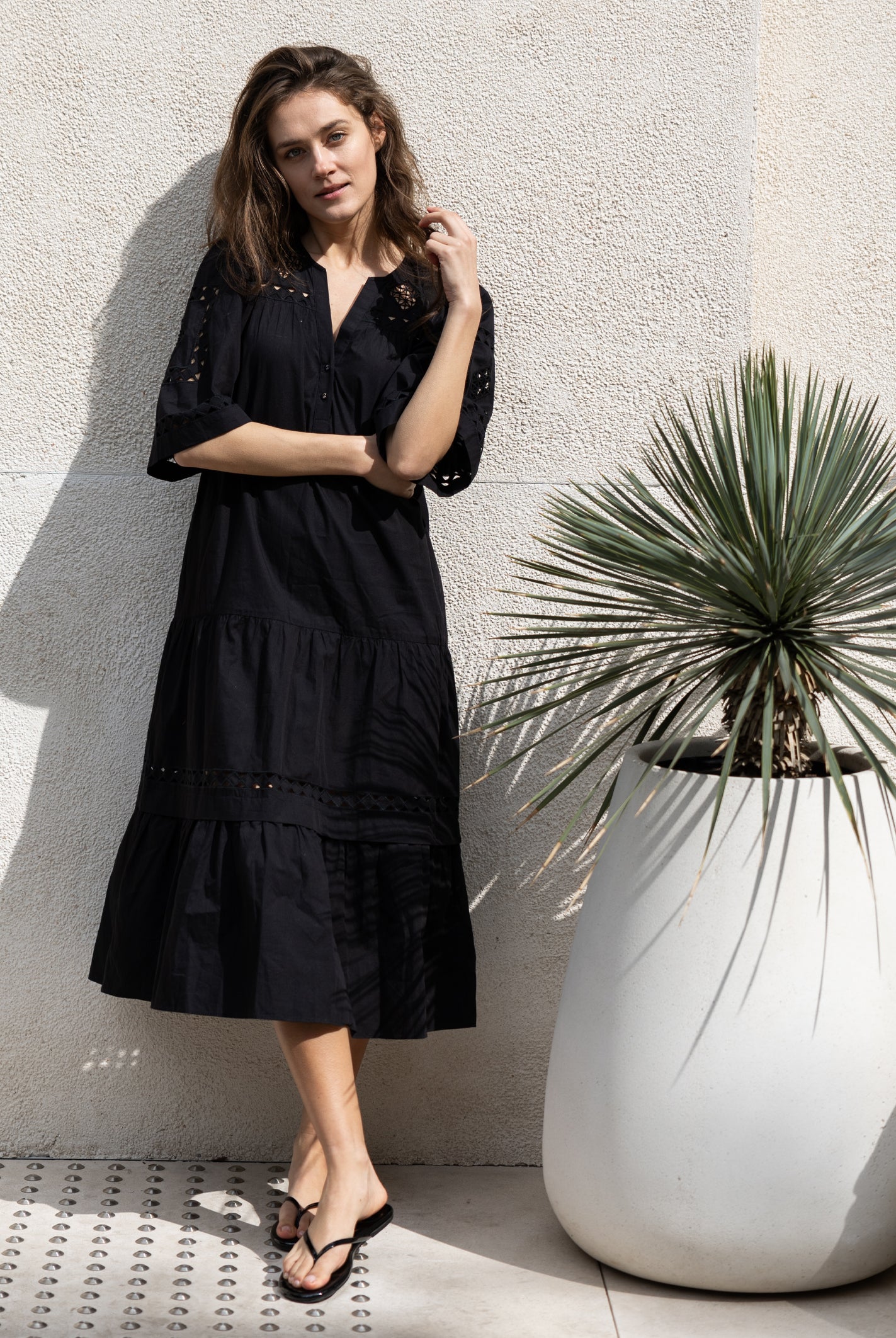 A model wears a Rose and Rose embroidered Biarritz dress in black cotton.