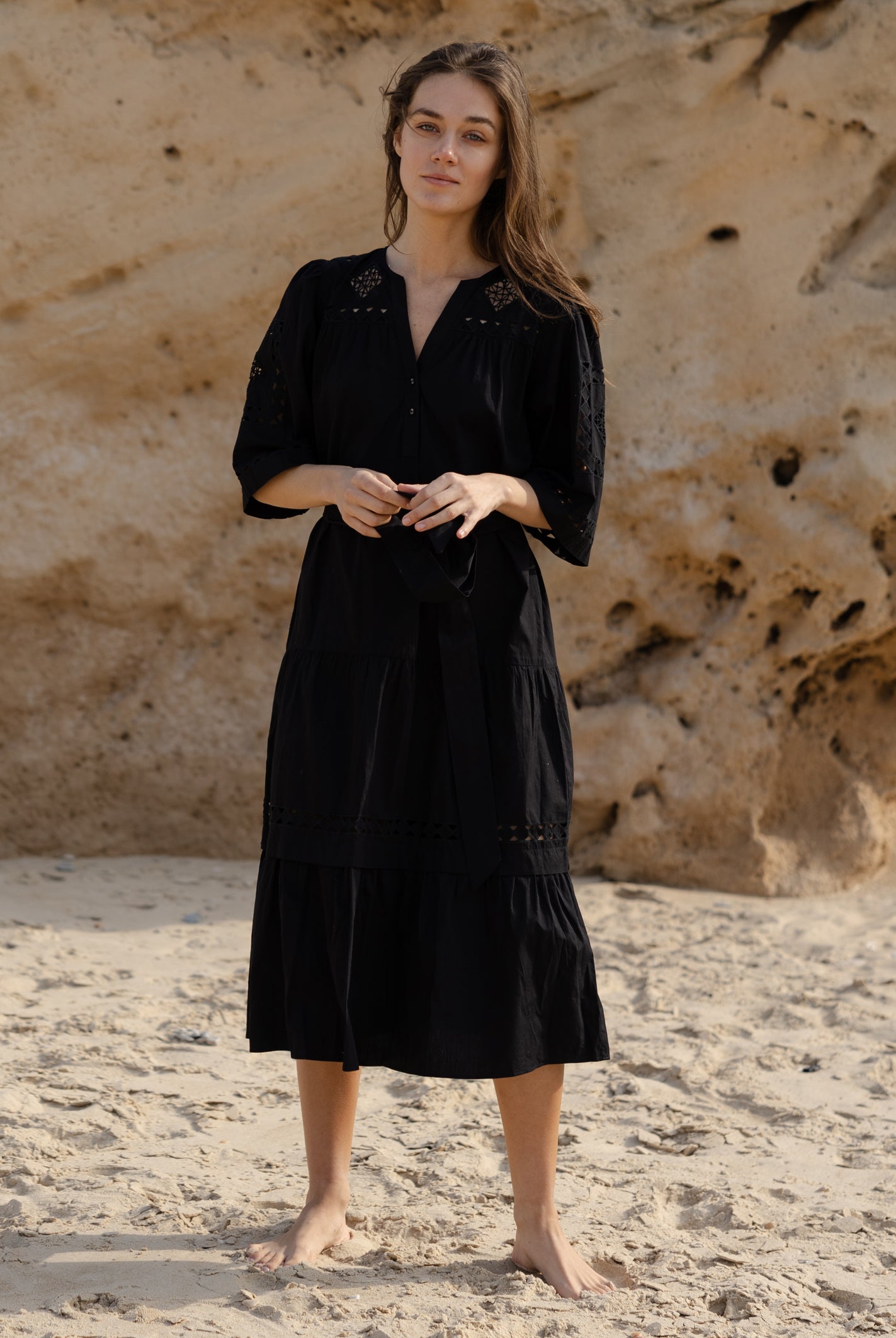 A model wears a Rose and Rose embroidered Biarritz dress in black cotton.