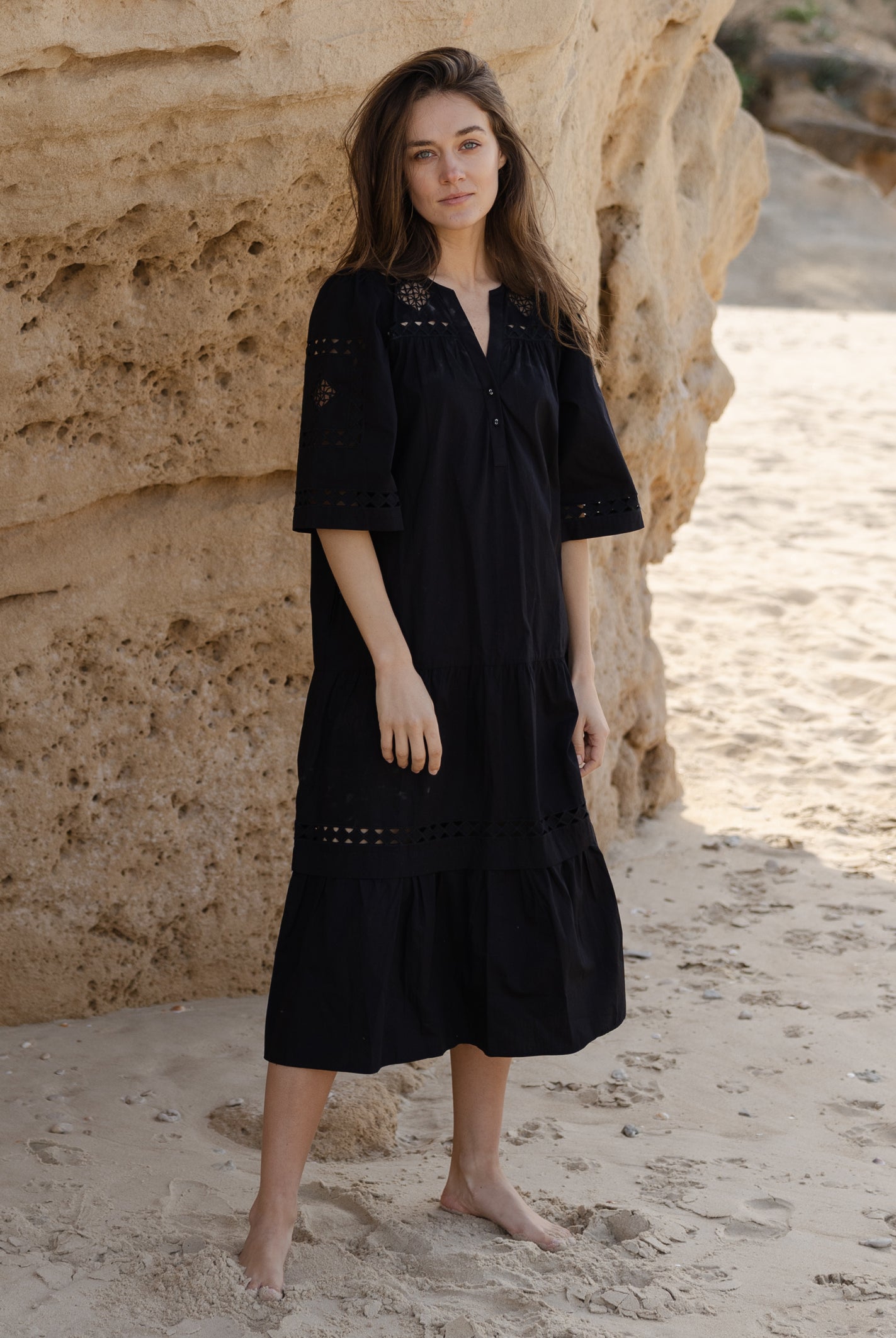 A model wears a Rose and Rose embroidered Biarritz dress in black cotton.