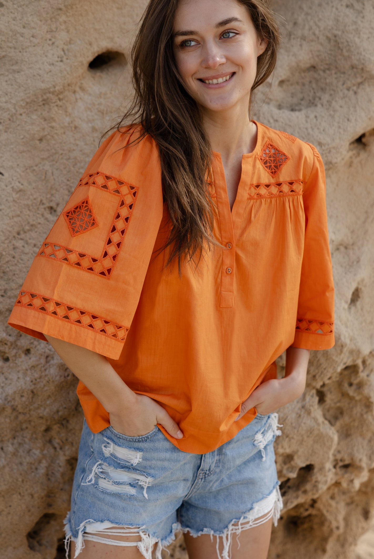 A model wearing a Rose and Rose embroidered Bordeaux top in Saffron orange cotton.