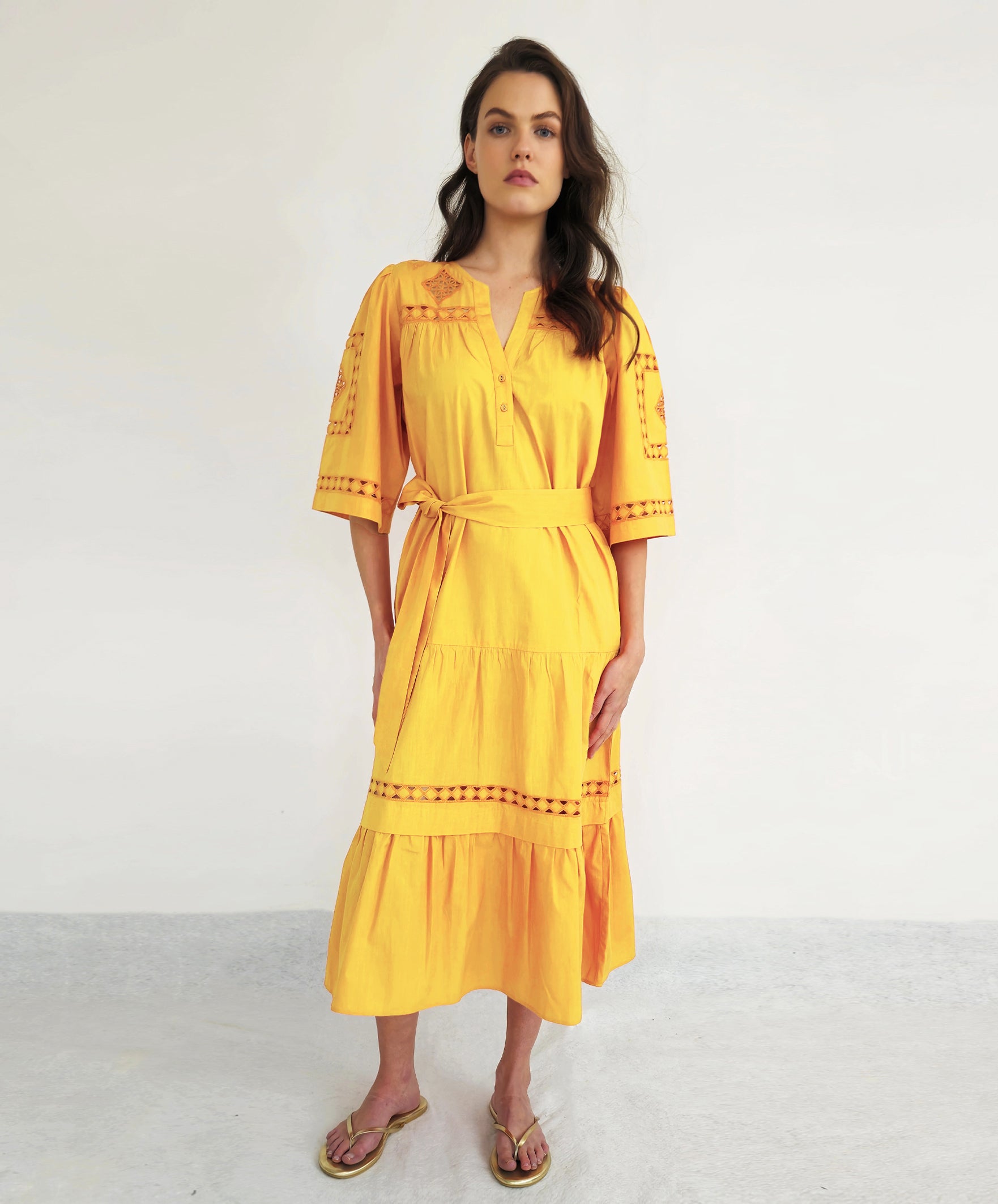 A model wears a Rose and Rose dress in Turmeric.