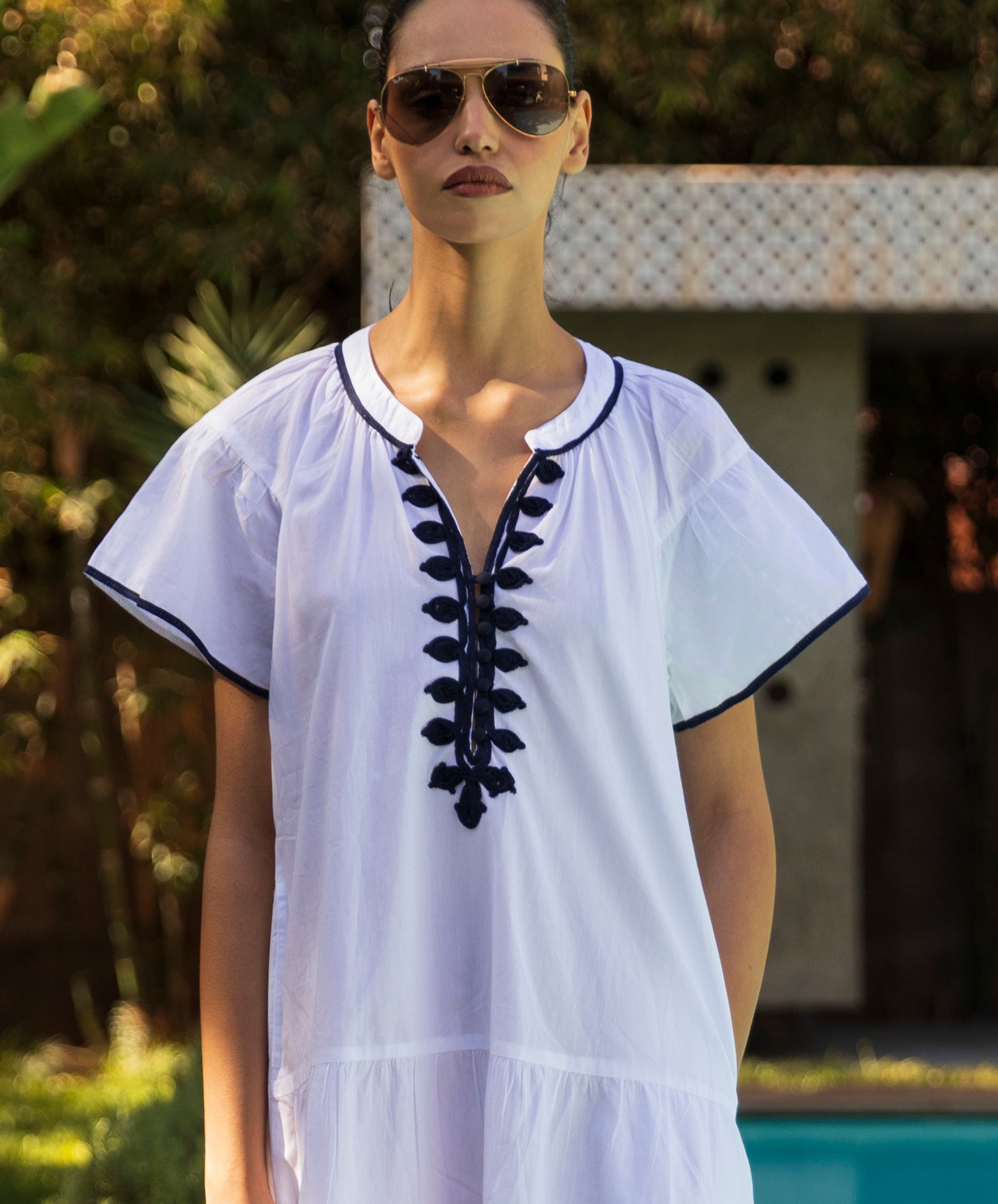 Woman wearing a white dress with navy passementerie decoration