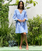 A model stood in a garden wearing a Rose and Rose blue Como dress.