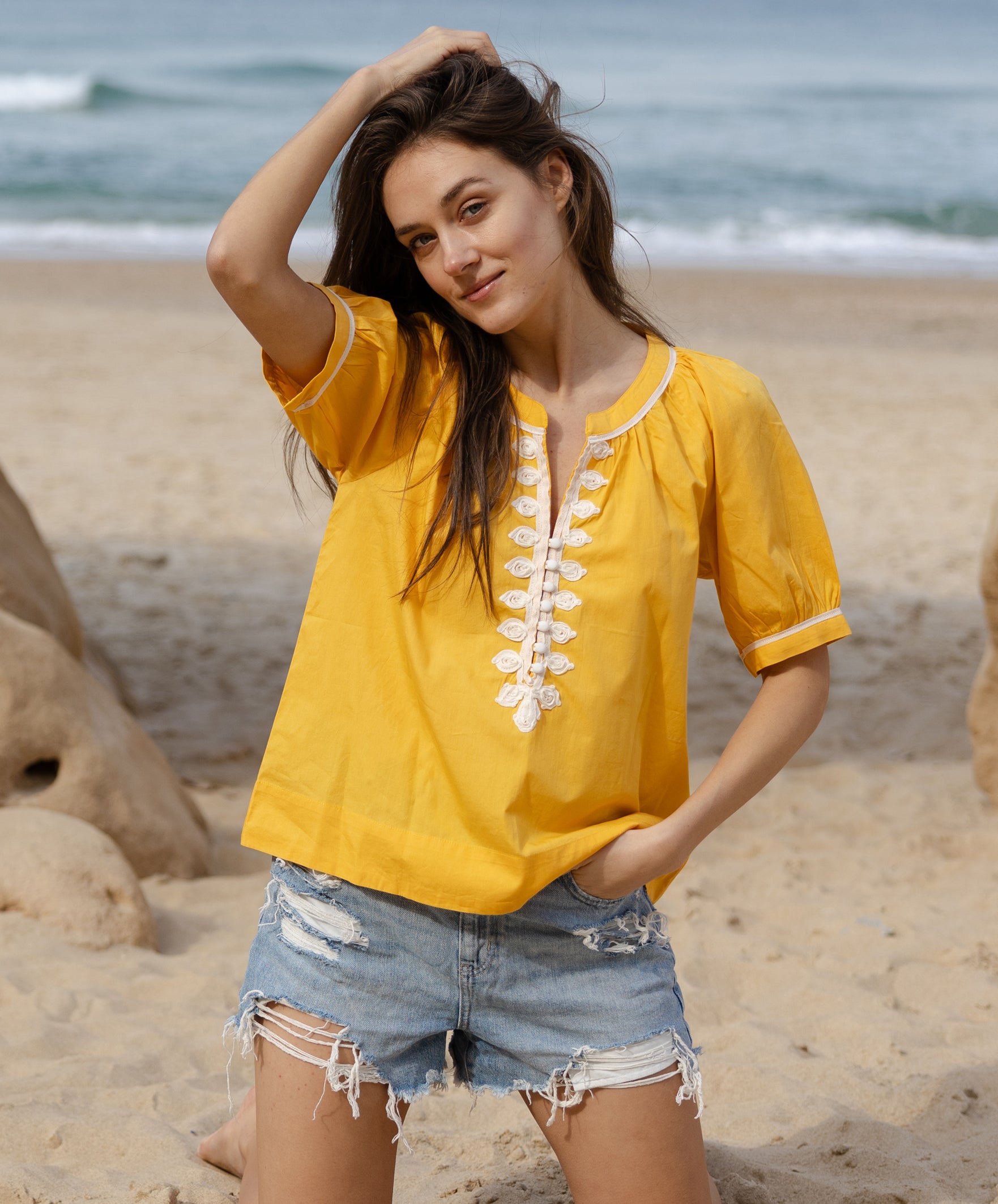 Model wears Rose and Rose yellow cotton Cote D'Azur top with passementerie decoration.