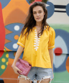 Model wears Rose and Rose yellow cotton Cote D'Azur top with passementerie decoration.