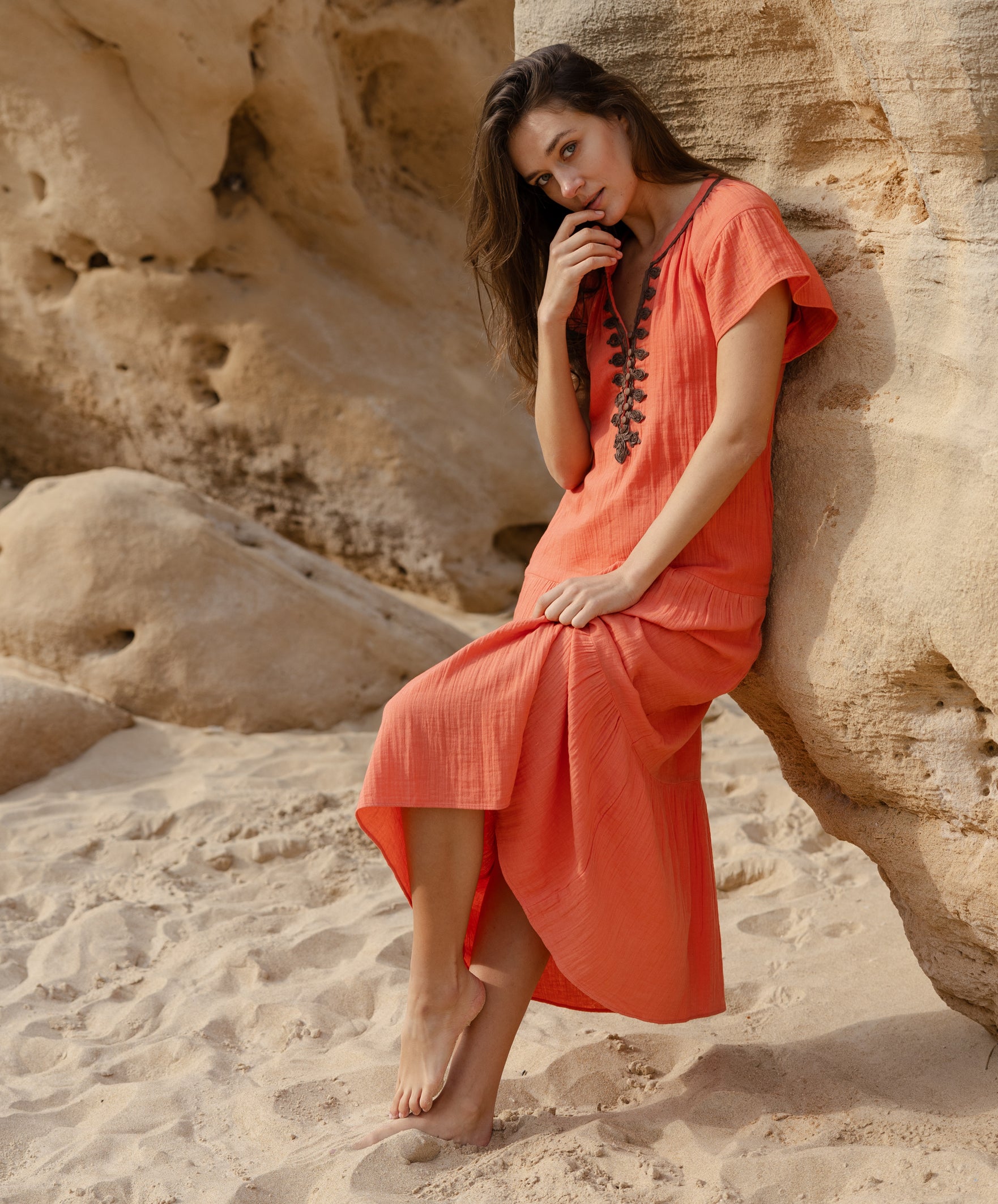 A model wearing a Rose and Rose Deauville coral maxi dress with passementerie decoration.
