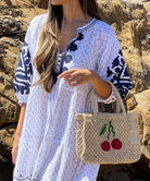 Close up of the Rose and Rose white Firenze dress and a jute bag from The Jacksons. 
