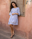 A model wearing a Rose and Rose blue cotton La Rochelle dress.