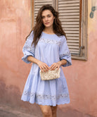 A model wearing a Rose and Rose blue cotton La Rochelle dress.
