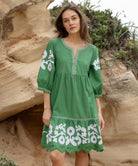 A model wearing a Rose and Rose Nice dress in leaf green cotton.