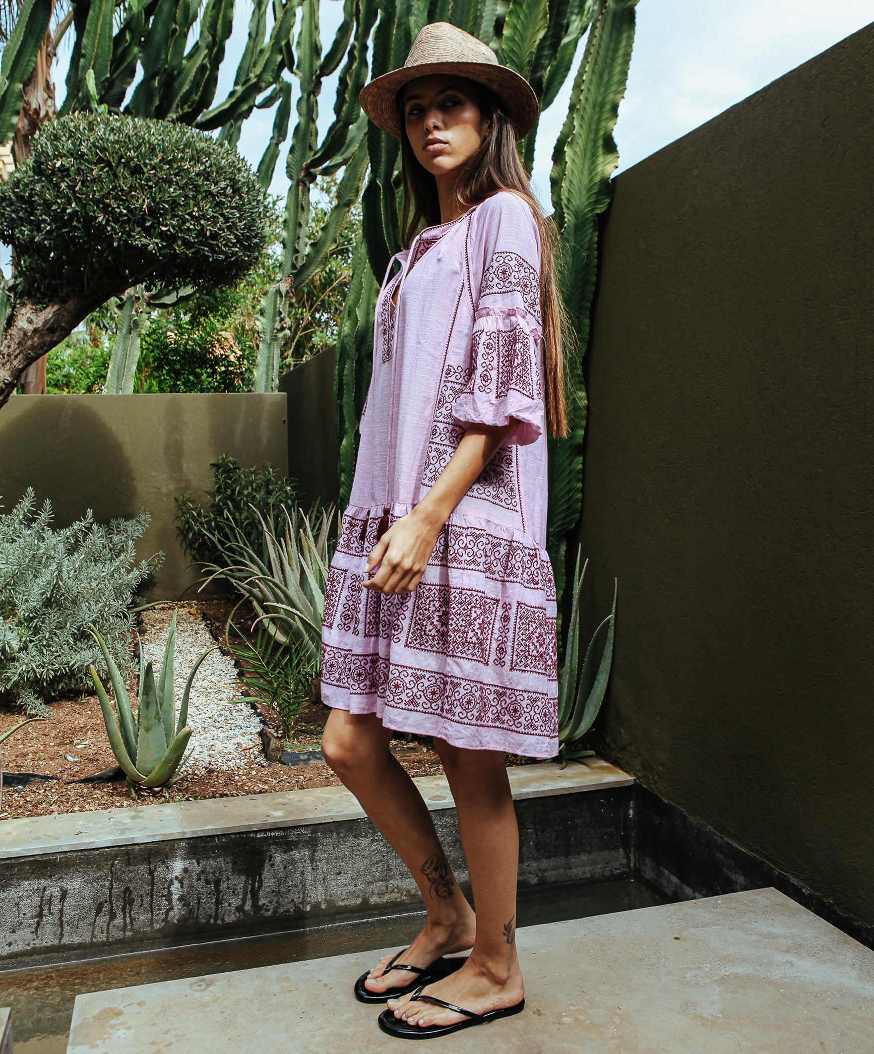 Side view of a model wearing a Rose and Rose embroidered Notting hill pink dress.