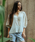 A model wearing a Rose and Rose Oval top in white with gold lurex dobby decoration.
