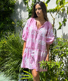 A model stood in a garden wearing a Rose and Rose pale pink Palermo embroidered dress. 