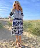 A model stood in sand dunes wearing a Rose and Rose striped linen Portafino dress.
