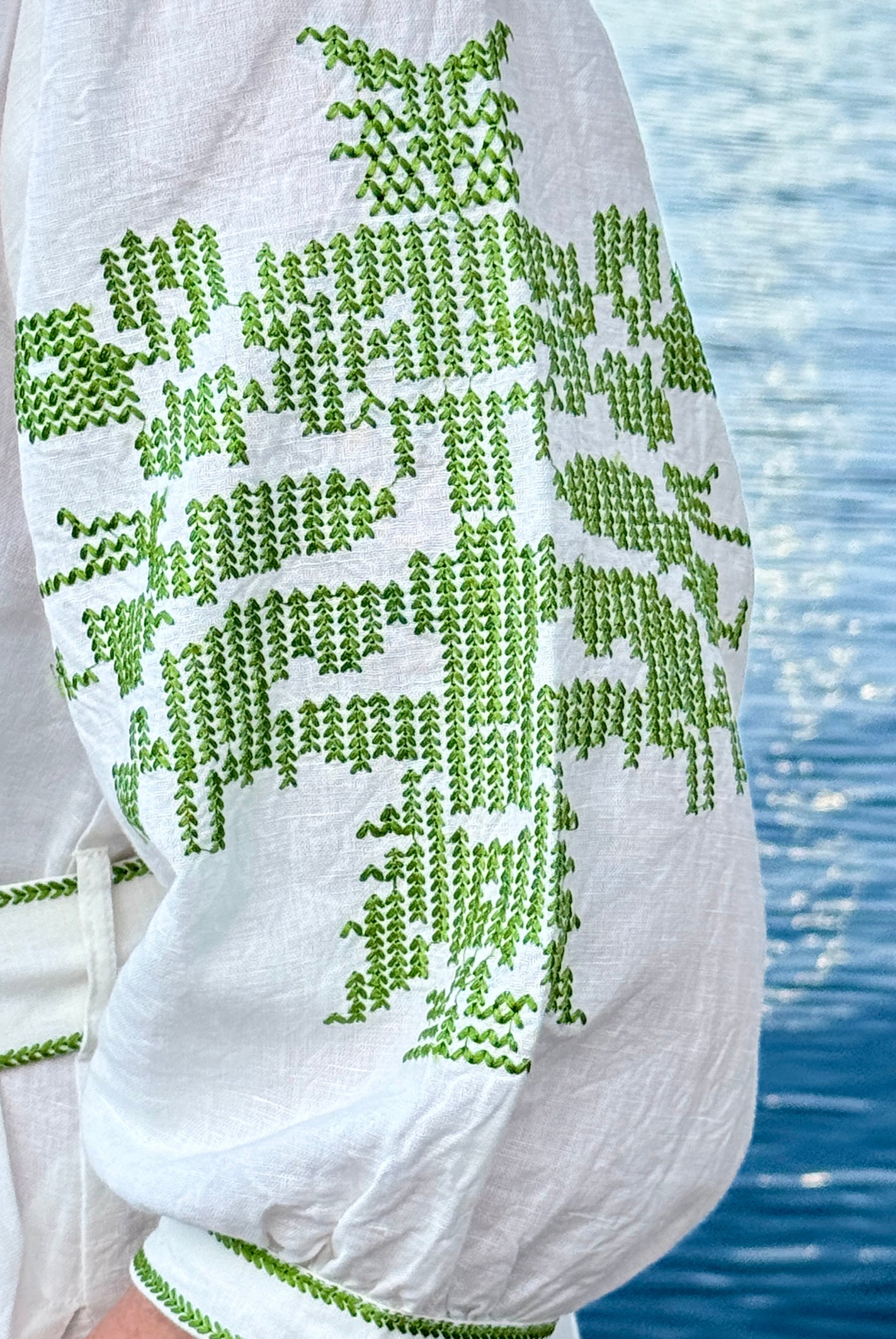 Olive green embroidery details on the sleeve of the white Pine dress.