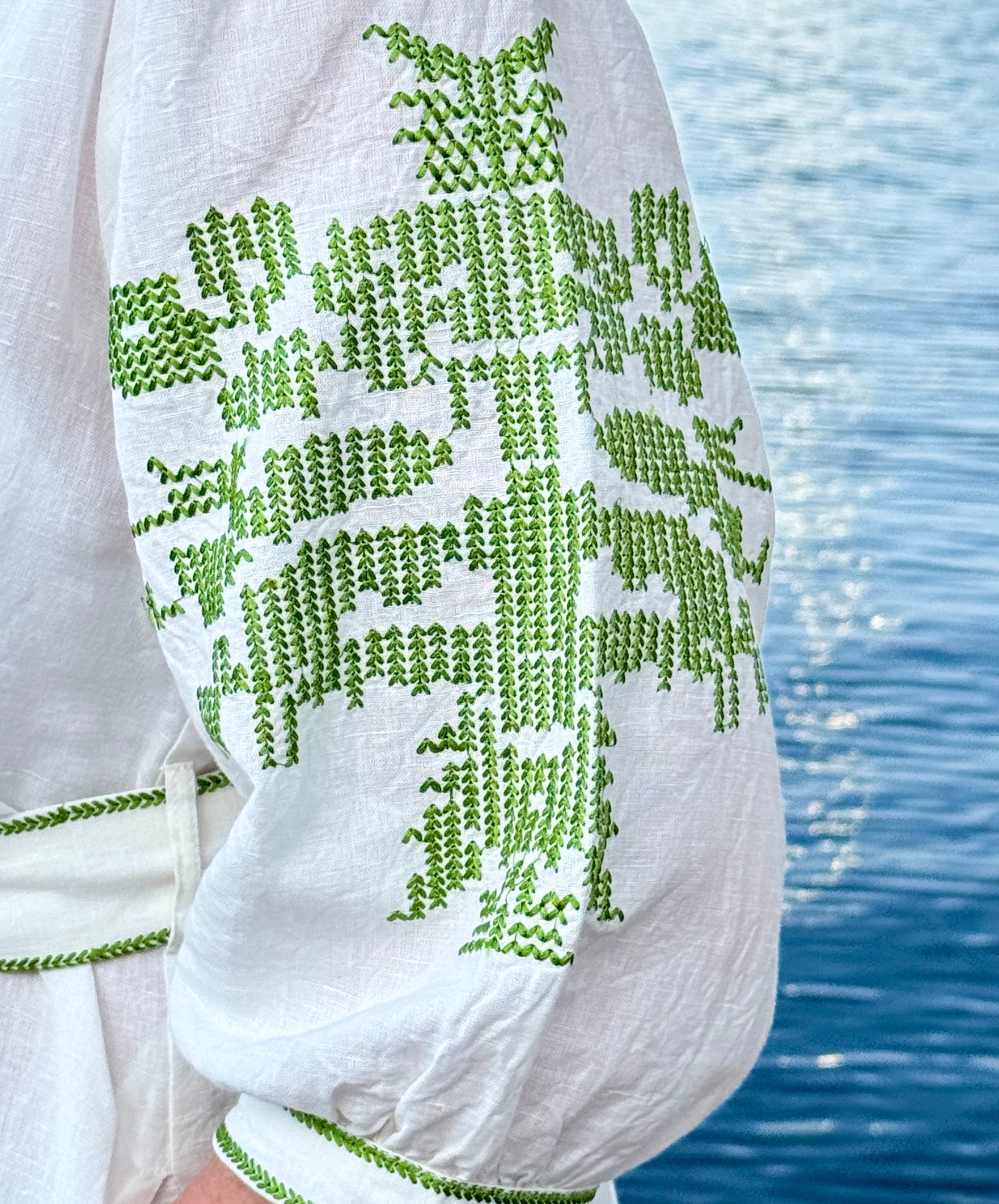 Olive green embroidery details on the sleeve of the white Pine dress.