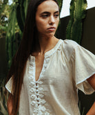 Details of the Rose and Rose gold Upminster top with white passementerie decoration.