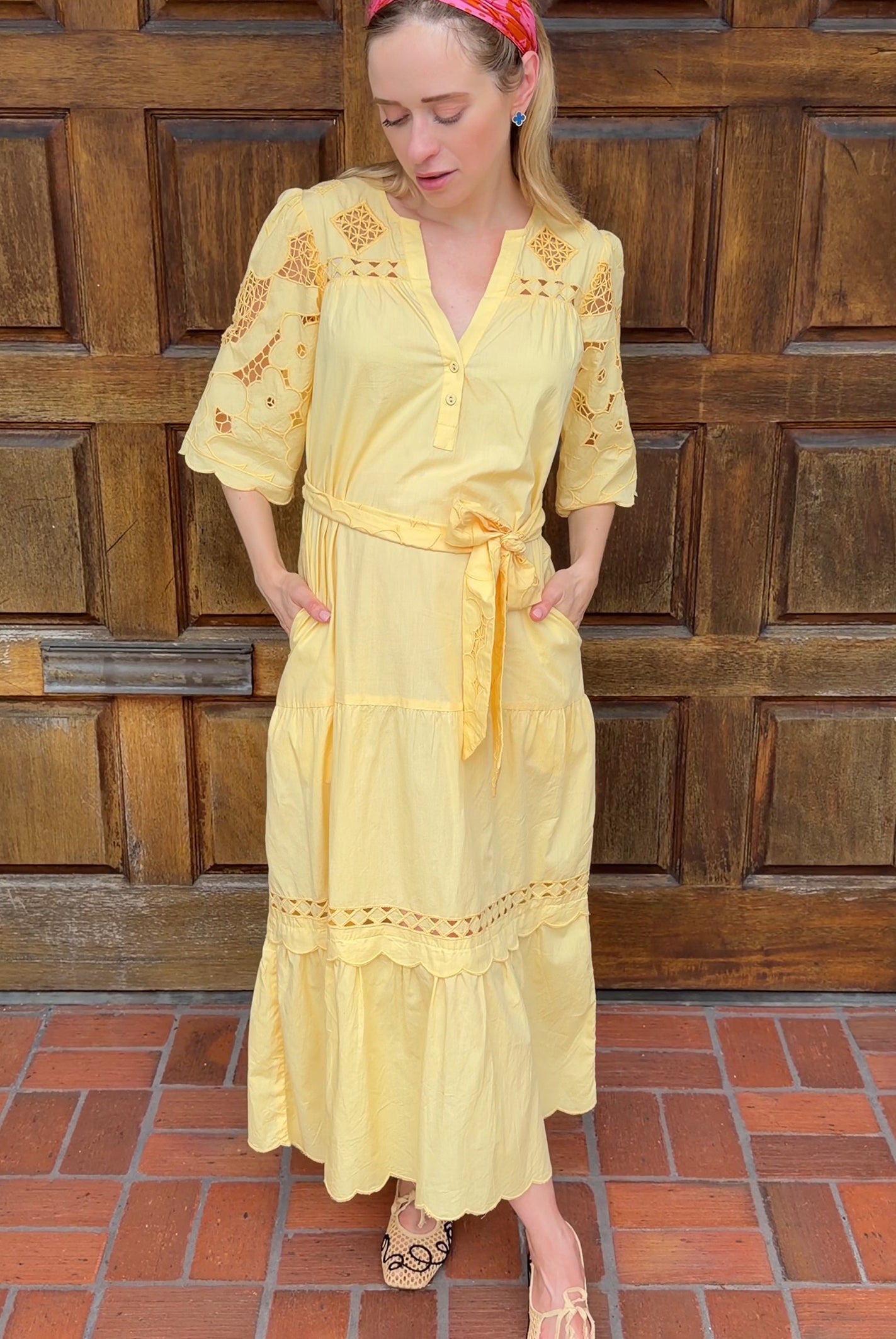 Influencer @viktoria_myr wearing the Dahlia dress in pale yellow in front of a wooden doorway.