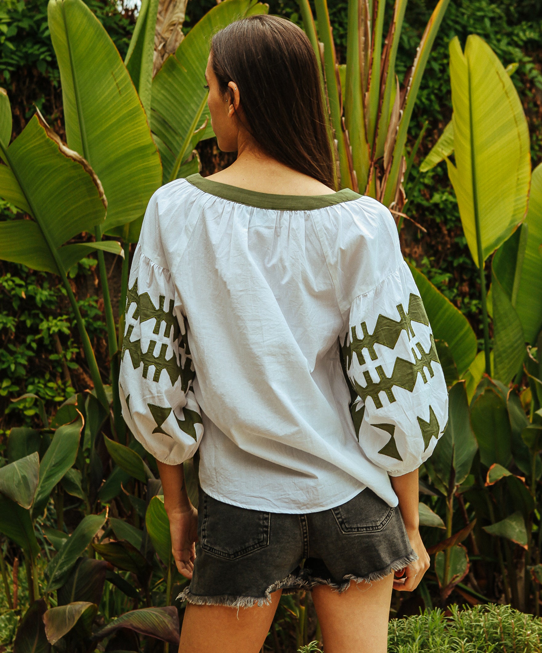 A back view of a model wearing a Rose and Rose Aldgate top in white and olive cotton.