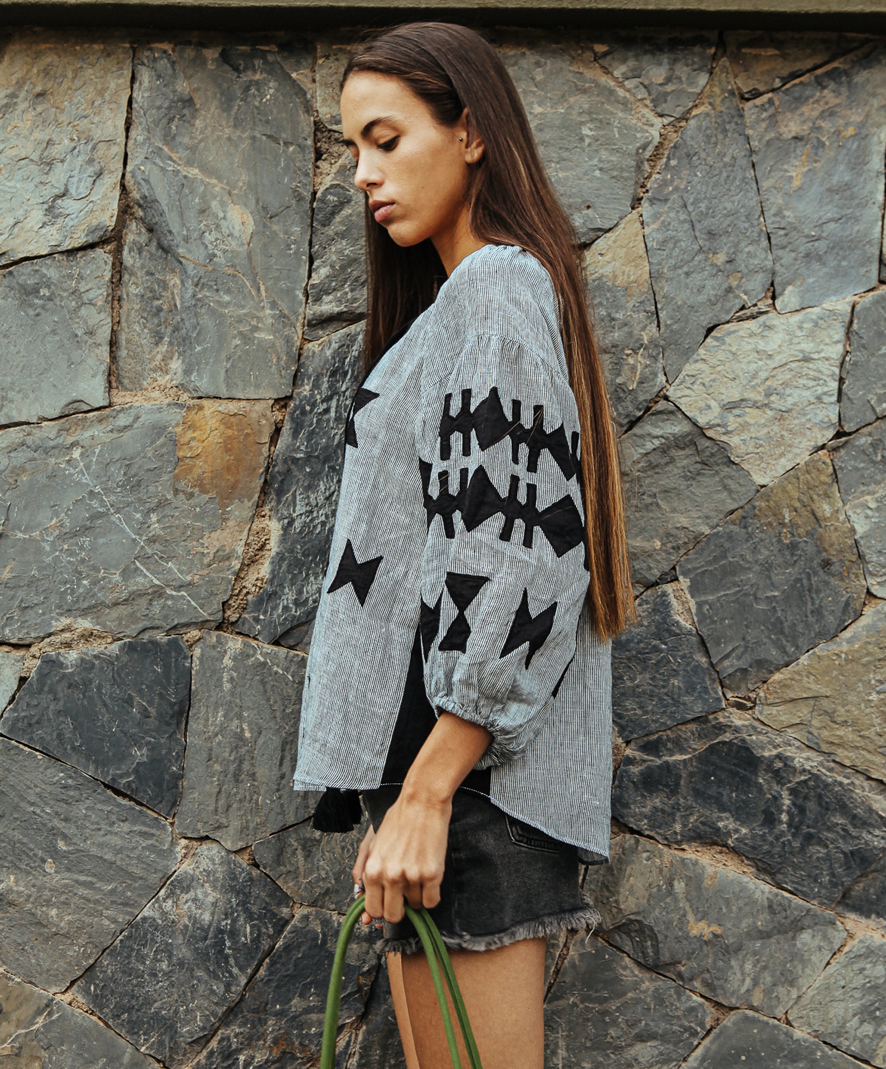 Side view of a model wearing a Rose and Rose striped linen Aldgate top. 