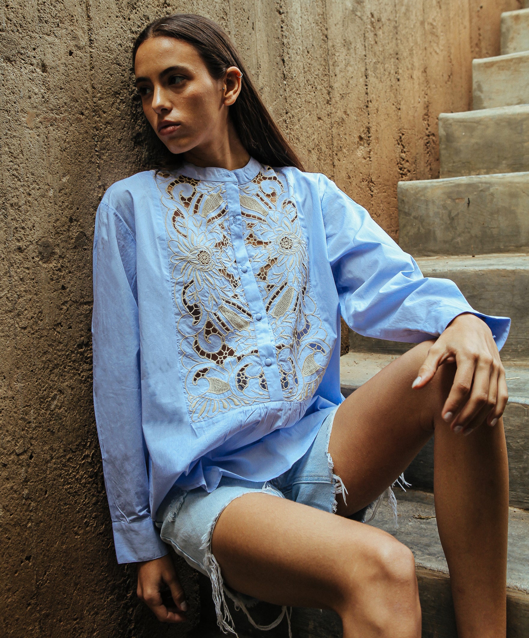 A model wearing a Rose and Rose Barbican embroidered shirt in blue cotton. 