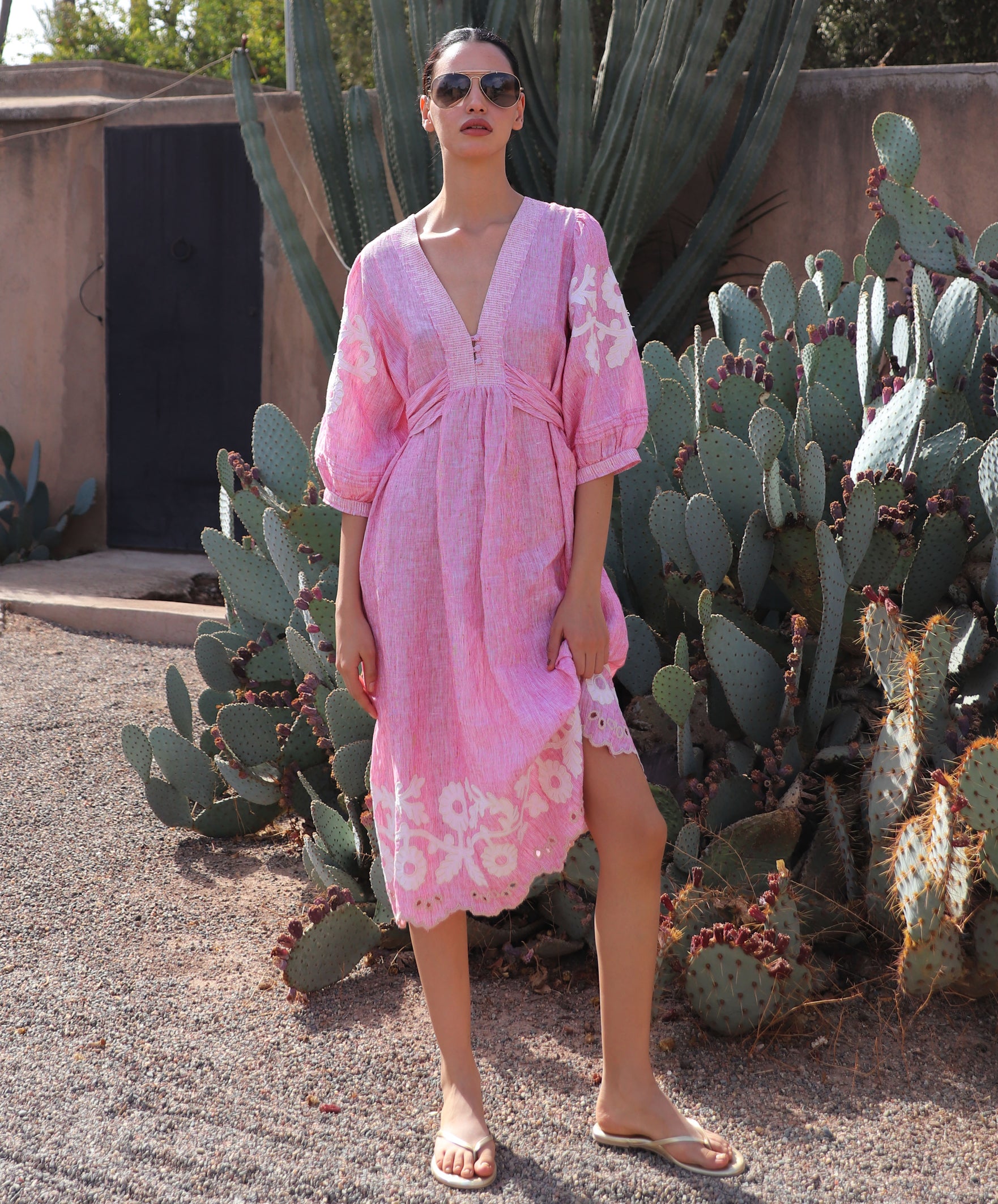 Woman in a red striped Begonia dress standing in front of cacti