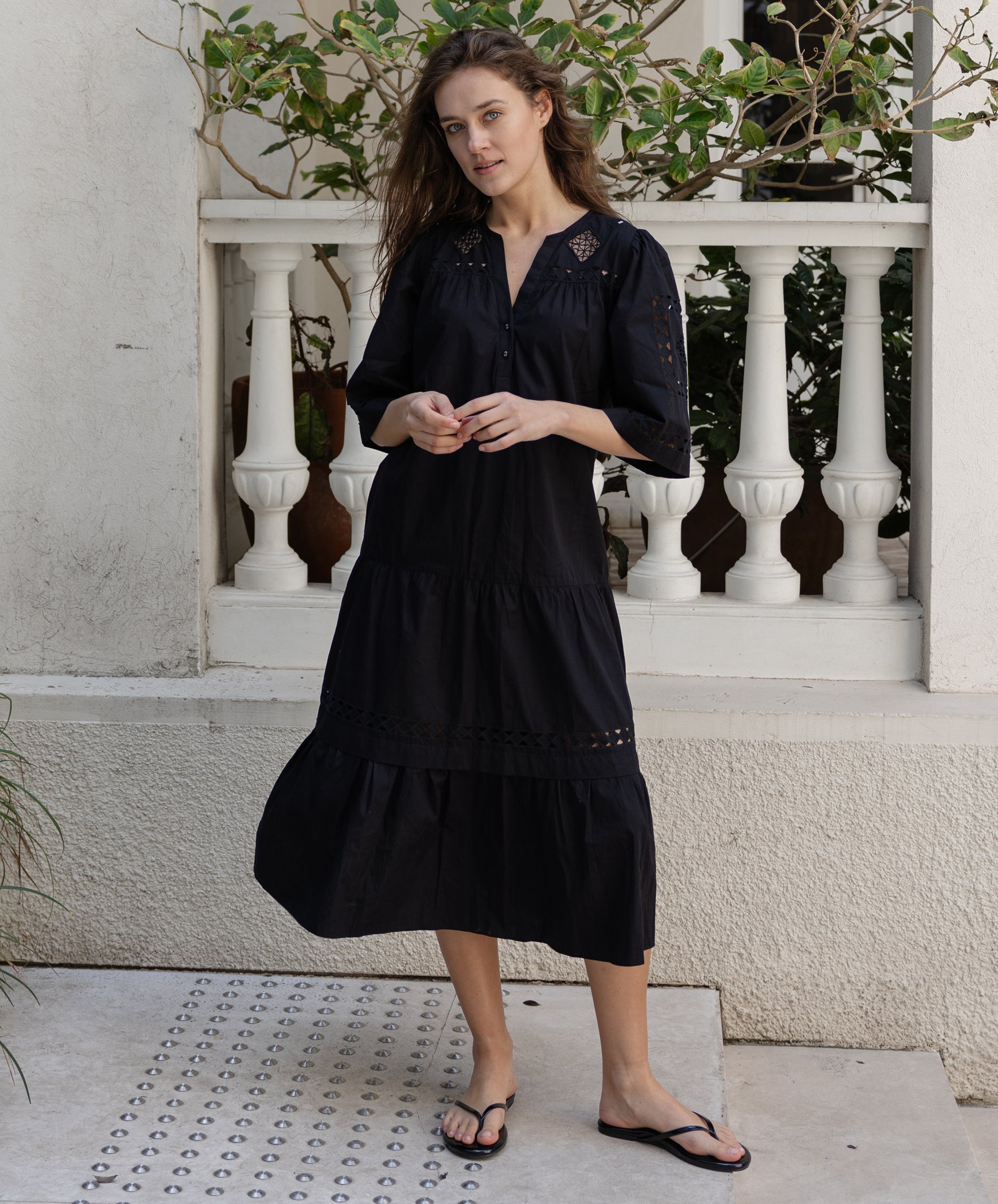 A model wears a Rose and Rose embroidered Biarritz dress in black cotton. 