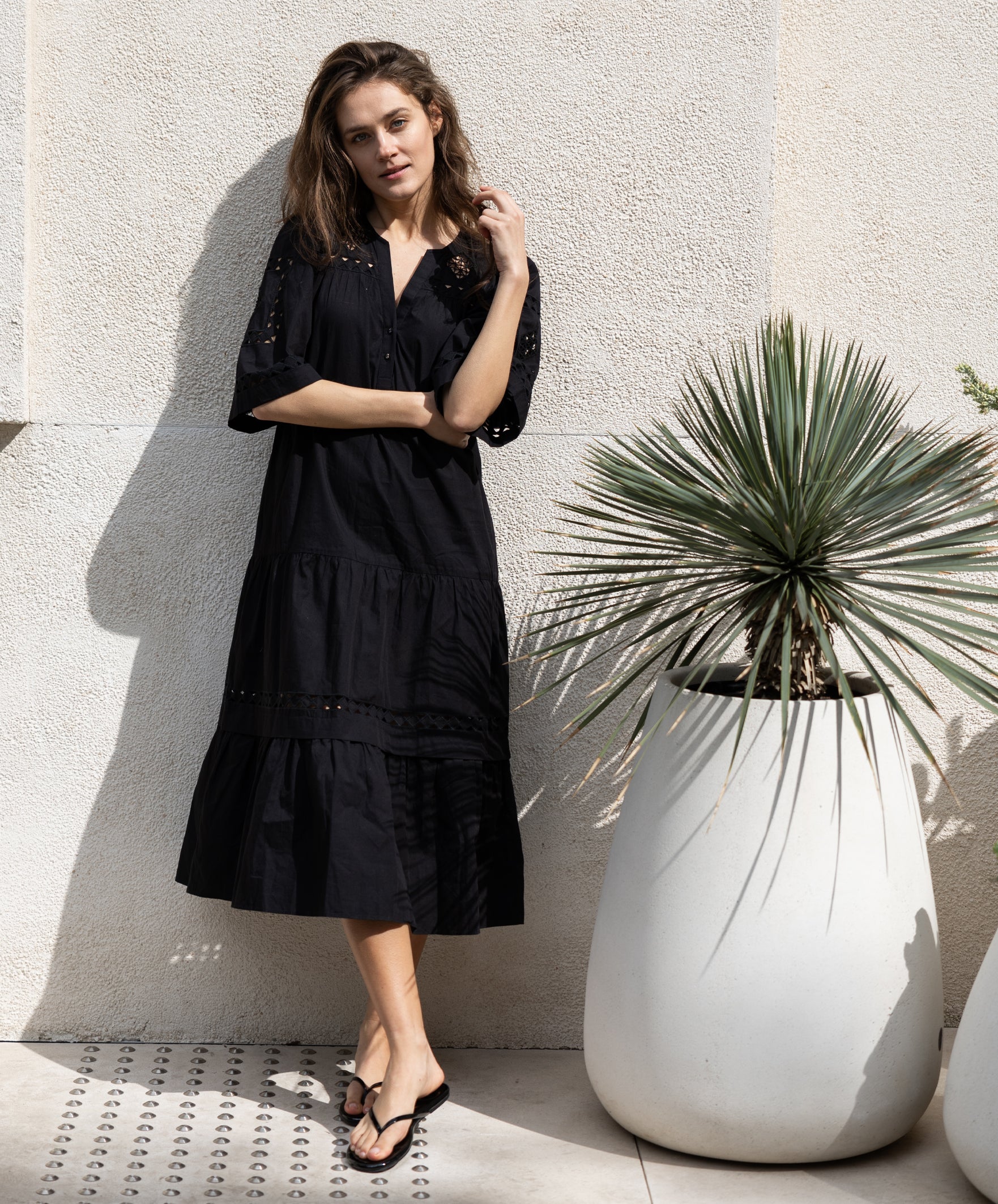 A model wears a Rose and Rose embroidered Biarritz dress in black cotton. 
