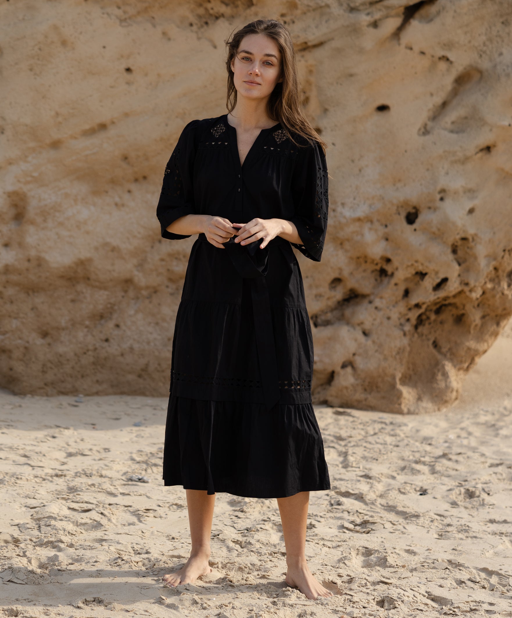 A model wears a Rose and Rose embroidered Biarritz dress in black cotton. 