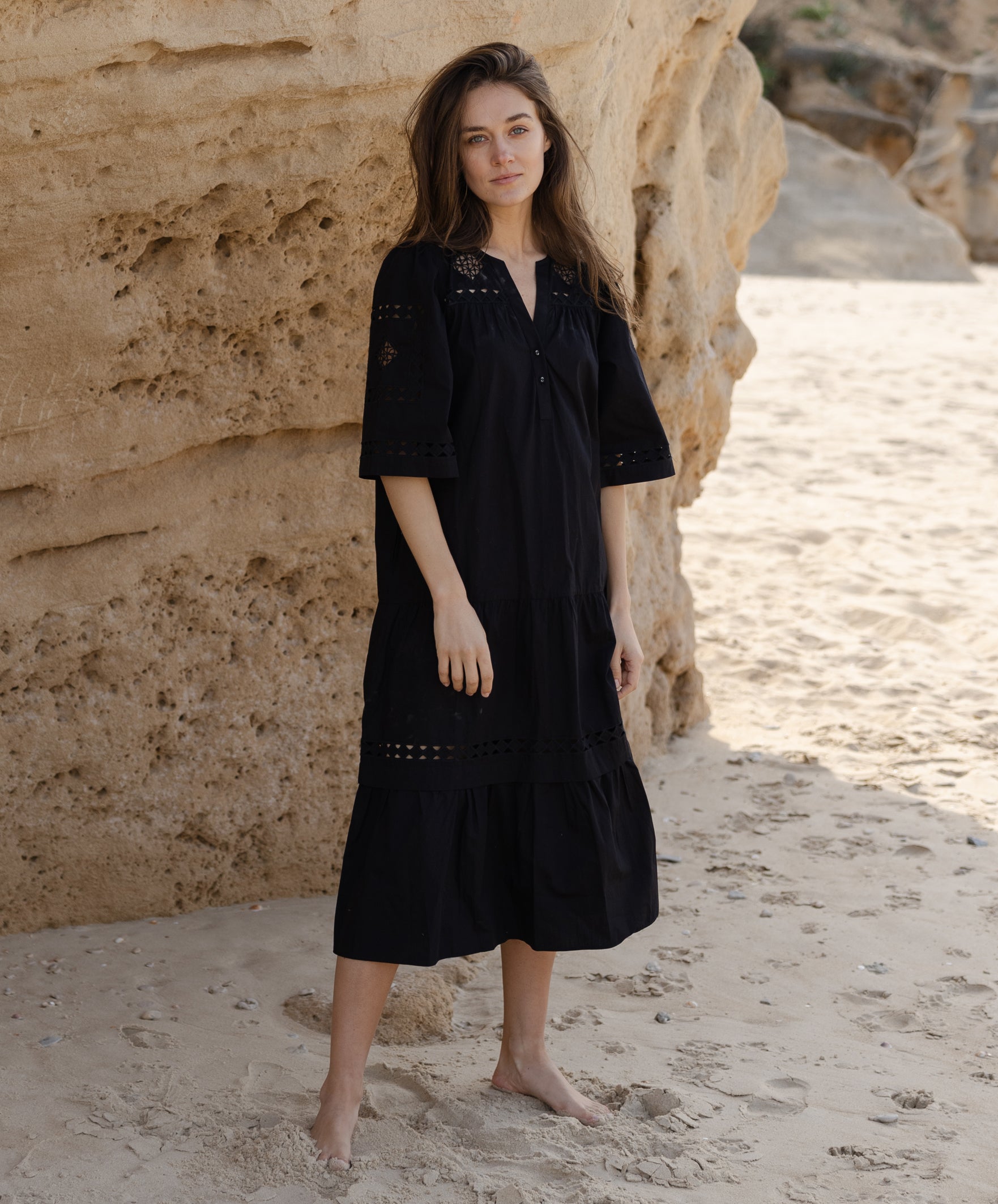 A model wears a Rose and Rose embroidered Biarritz dress in black cotton. 