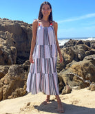 A model stood on a beach wearing a Rosebud by Rose and Rose Bias Dress.