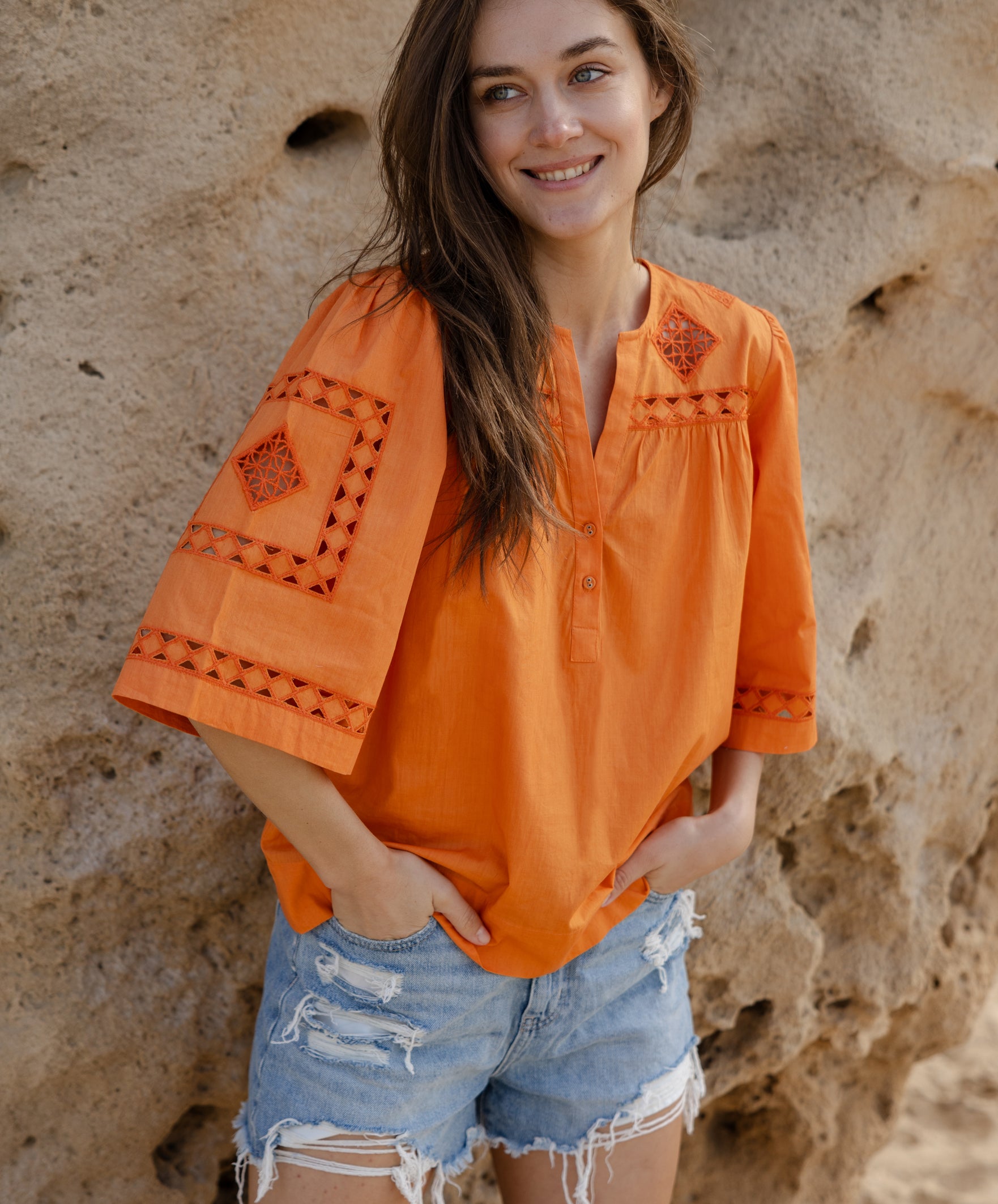 A model wearing a Rose and Rose embroidered Bordeaux top in Saffron orange cotton.