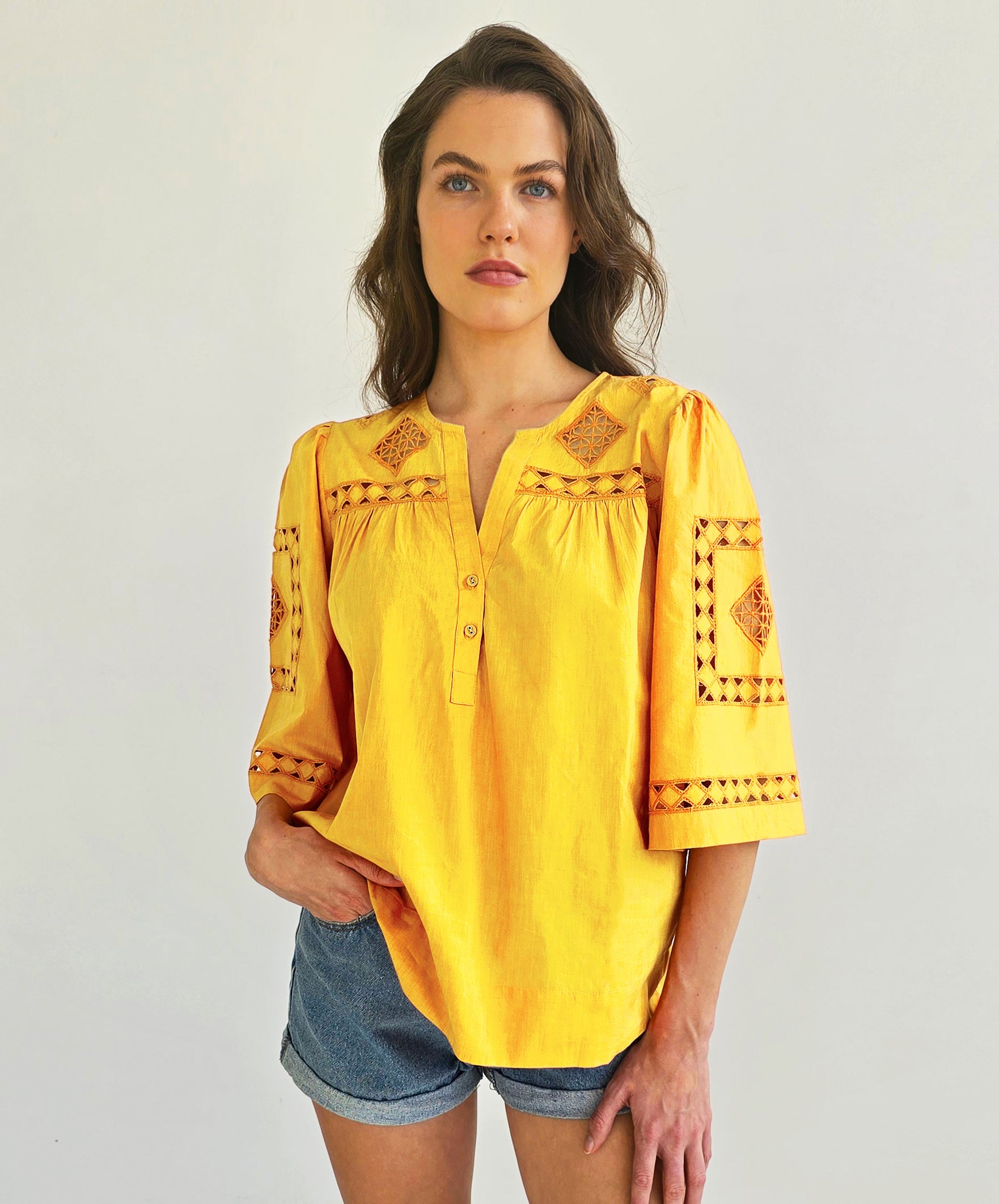 A model wearing a Rose and Rose Bordeaux top in turmeric.