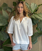 A model wearing a Rose and Rose Bordeaux top in white.