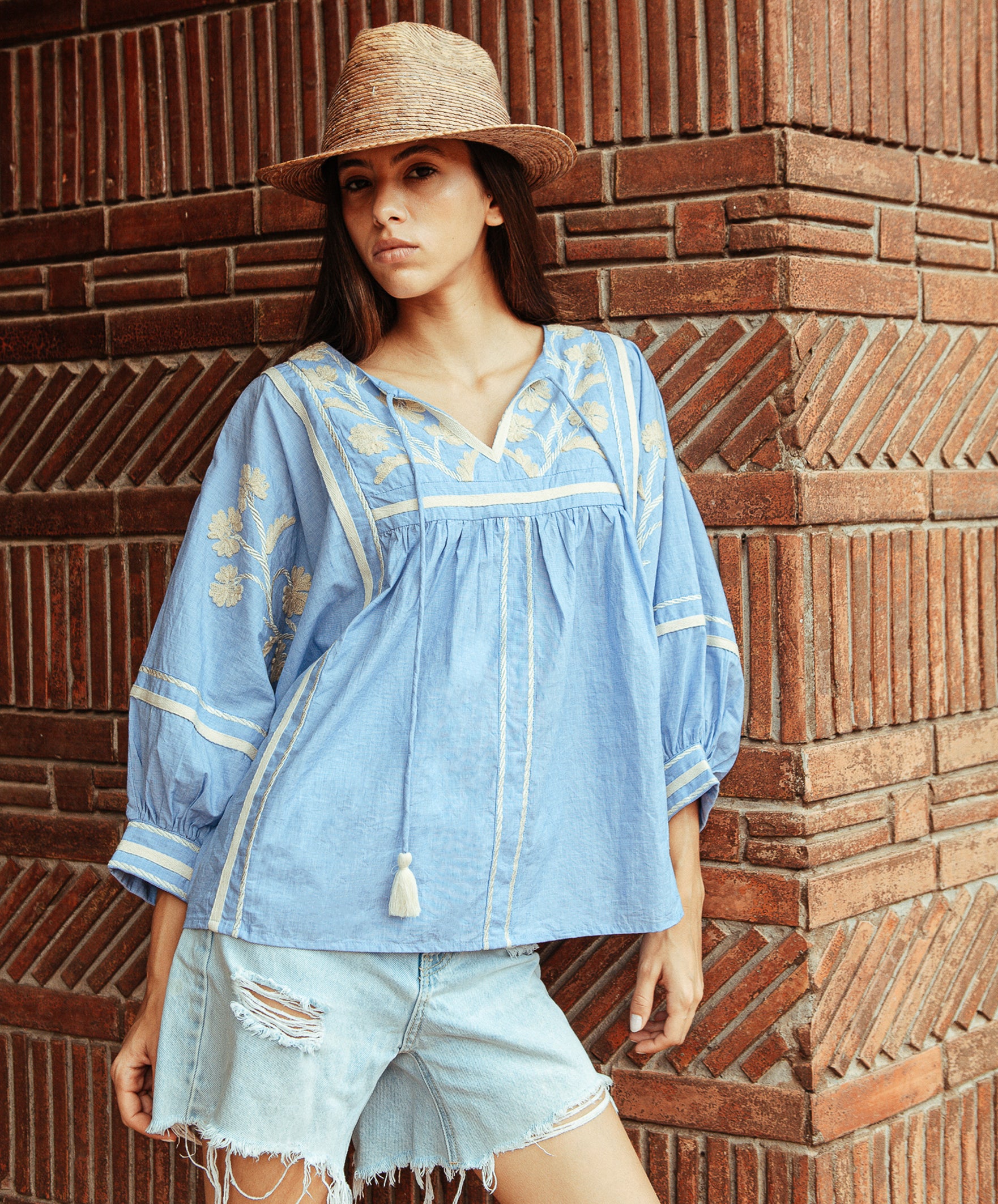 A model wears a Rose and Rose Camden embroidered top in blue. 