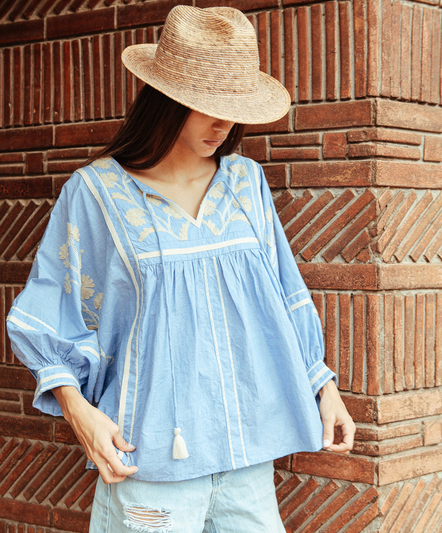 A model wears a Rose and Rose Camden embroidered top in blue. 