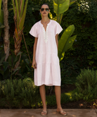 Woman wearing a light pink dress standing in a garden setting