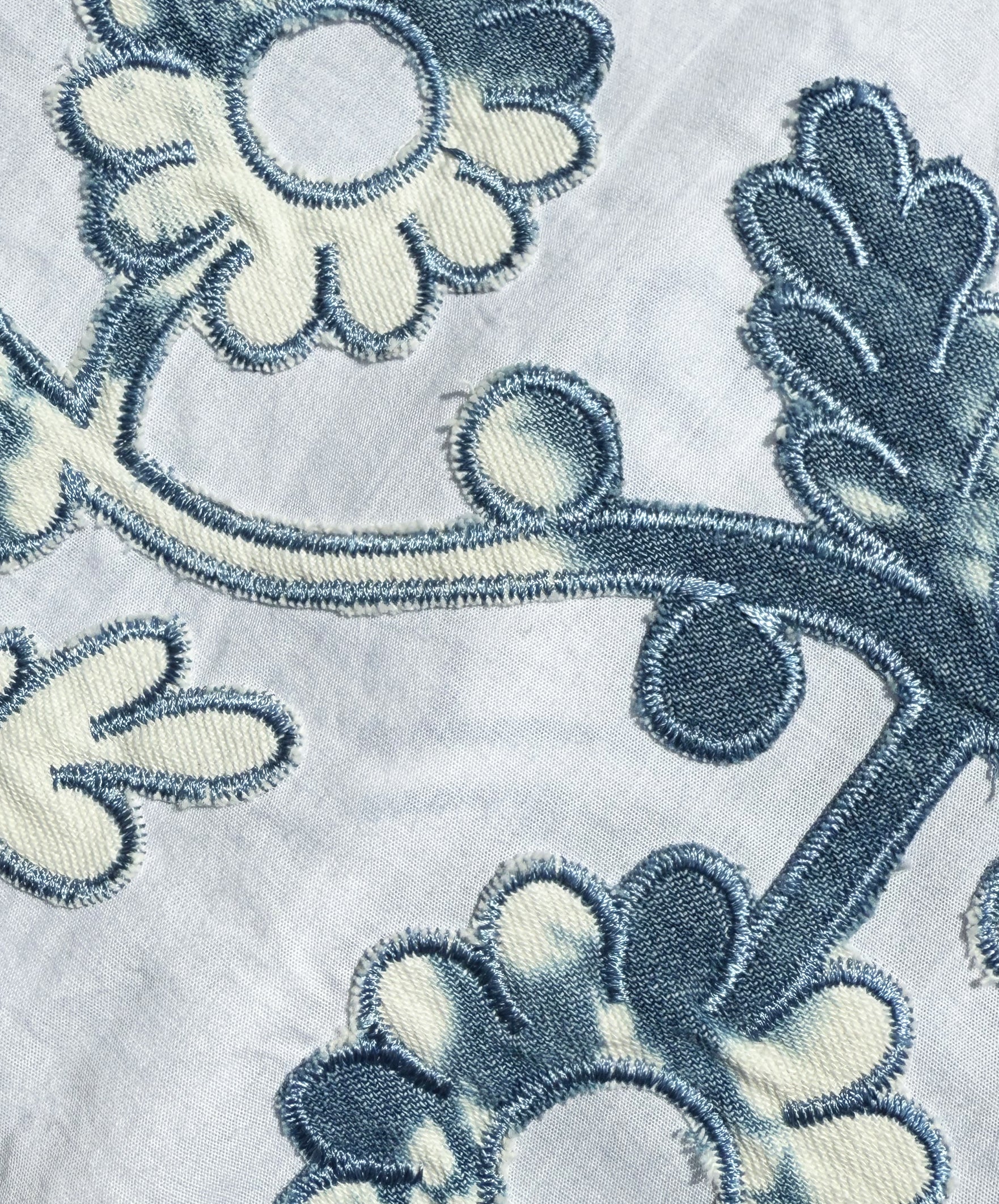 Close up of the Cedar dress applique decoration in distressed denim.