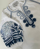 White blouse with blue embroidery on a light background